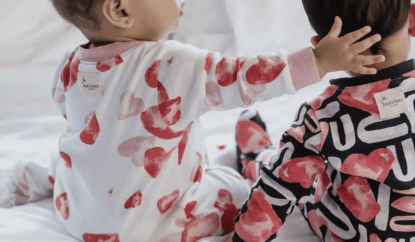 Two babies in heart-patterned pajamas celebrate Valentines Day.